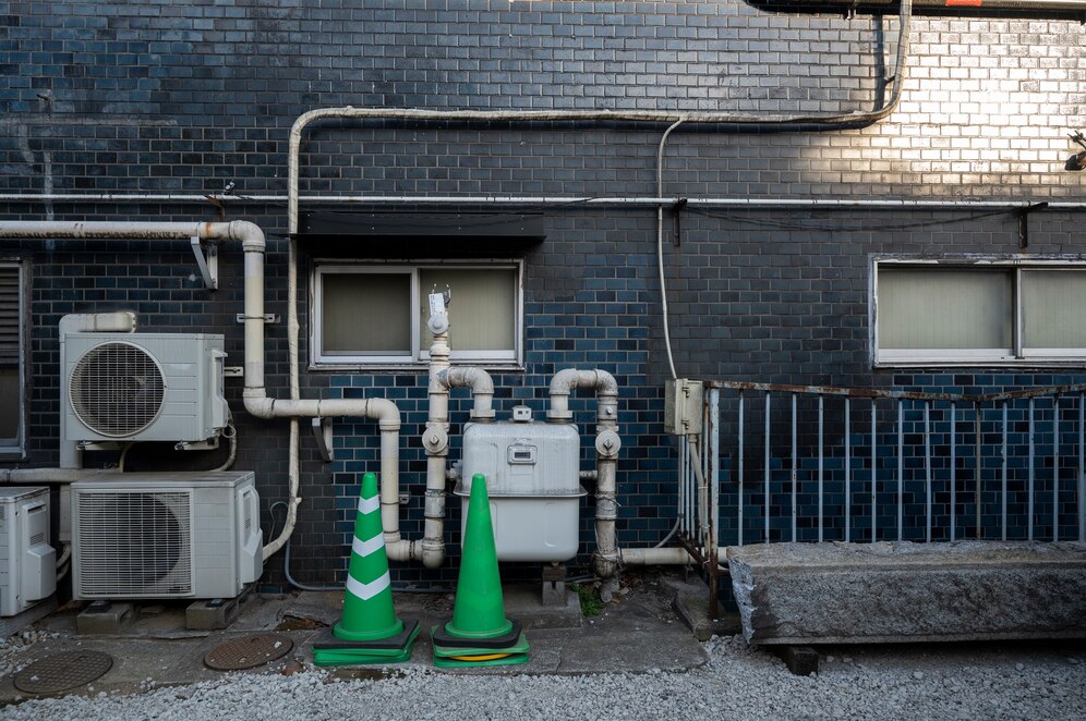 Outdoor HVAC air conditioning units and utility piping on a commercial building