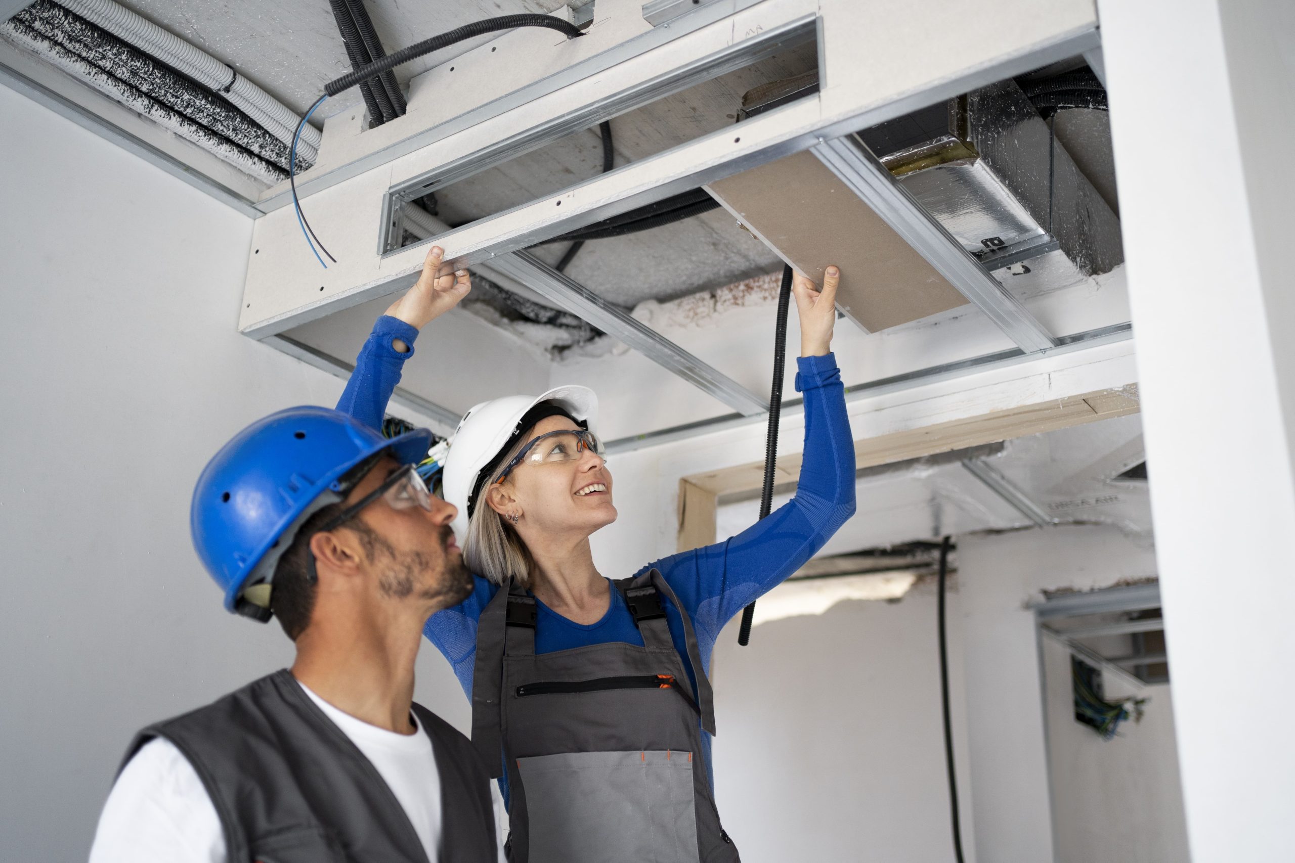 HVAC technicians inspecting ductwork during installation